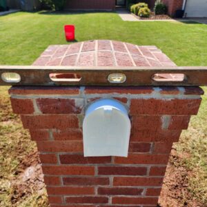Front view of brick mailbox repair example with level check in progress